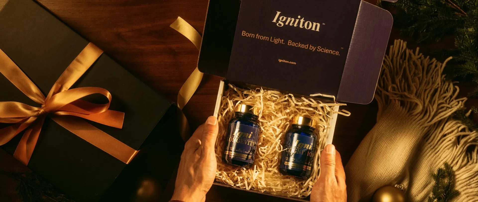 Hands open an Igniton gift box holding IgniLongevity and IgniCognition